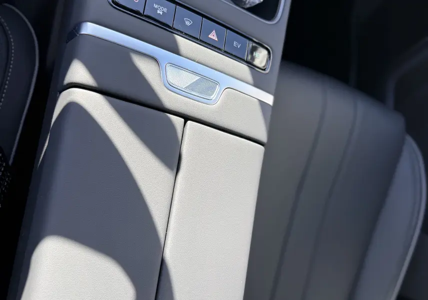 Vue rapprochée de la console centrale grise du JAECOO J7 PHEV 2026, avec boutons de commande et siège en cuir visible.