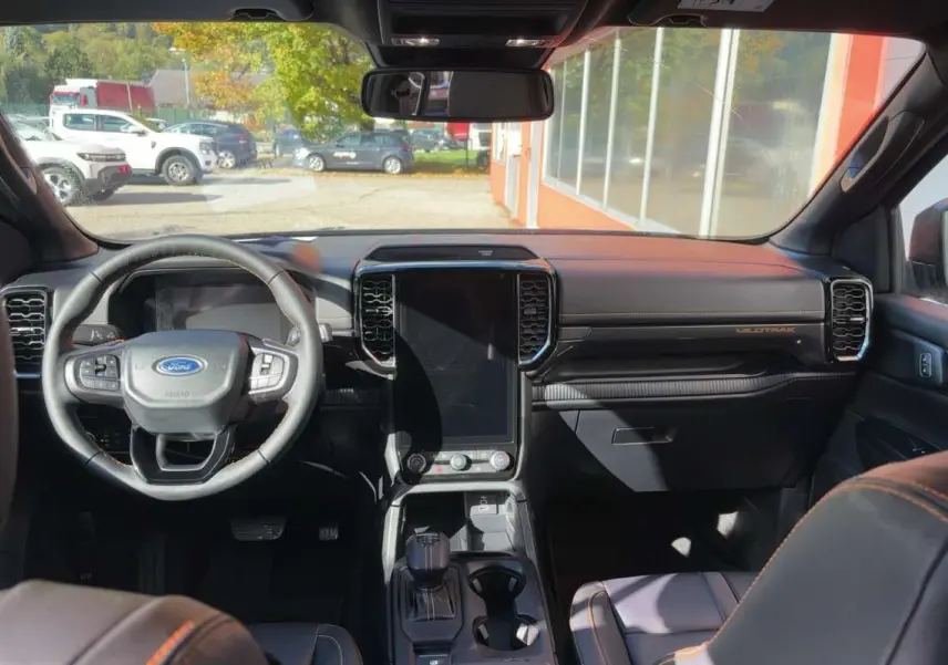 Vue intérieure avant du Ford Ranger gris carbone 2026, avec grand écran tactile vertical et volant cuir multifonctions.