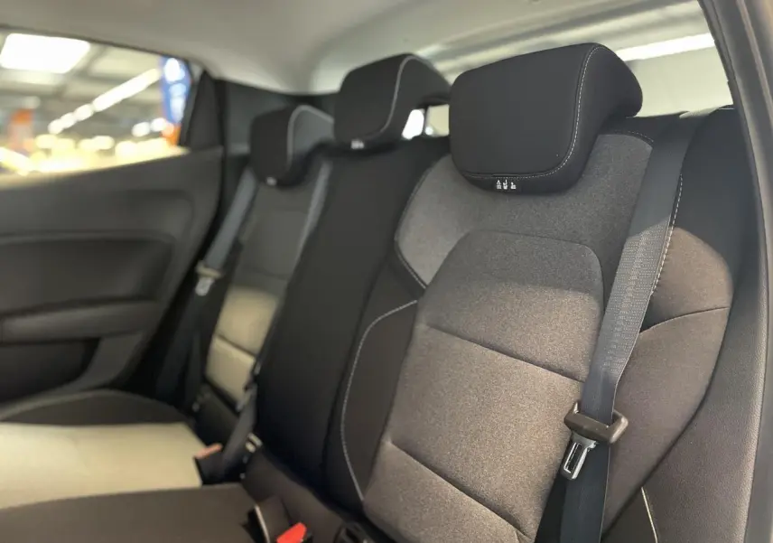 Vue intérieure du siège arrière droit de la Renault Clio 2025 avec sellerie tissu gris et ceinture de sécurité noire.