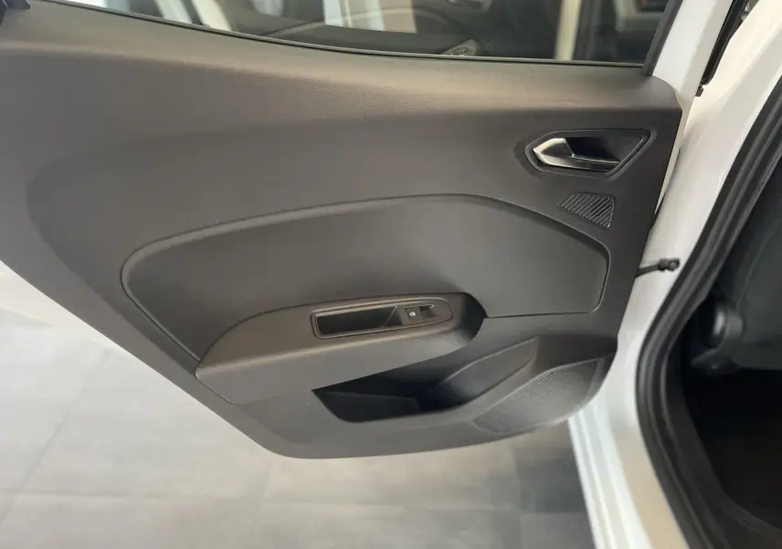 Porte intérieure côté arrière droit de la Renault Clio blanche 2025 avec poignée et commande de vitre noire.