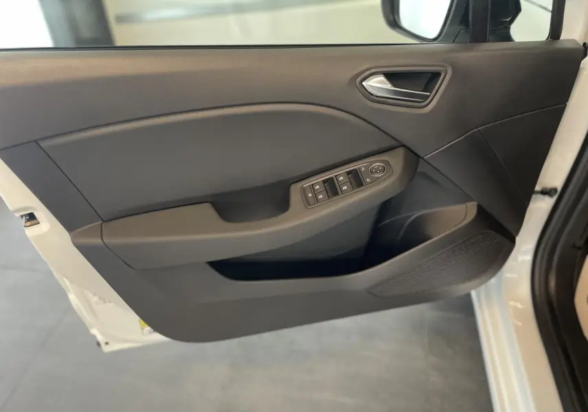 Vue intérieure de la porte avant gauche noire de la Renault Clio blanche avec commandes de vitres et rétroviseurs électriques.