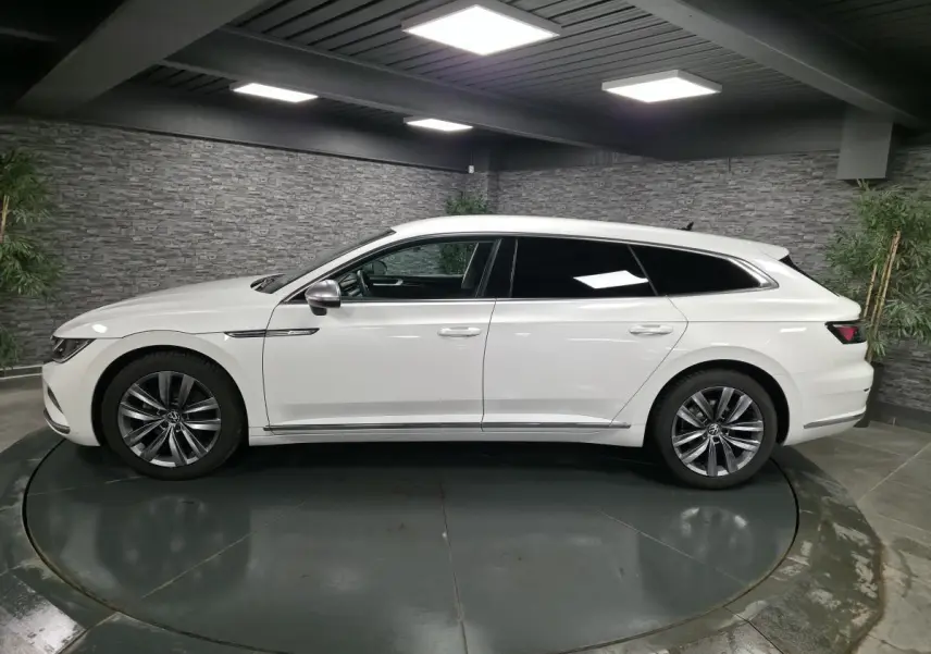 Volkswagen Arteon Shooting Brake blanc Oryx nacré, vue de profil côté gauche en intérieur avec jantes Almere 18 pouces.