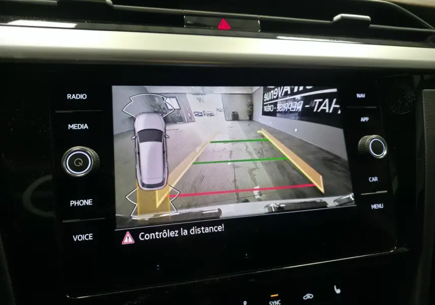 Vue de l'écran multimédia affichant la caméra de recul avec guidage de trajectoire du Volkswagen Arteon blanc.