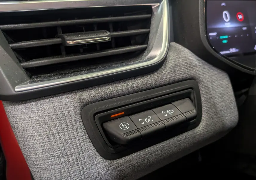 Détail des commandes d'éclairage et verrouillage sur tableau de bord gris d'une Renault Clio V Rouge Flamme, vue intérieure côté gauche.