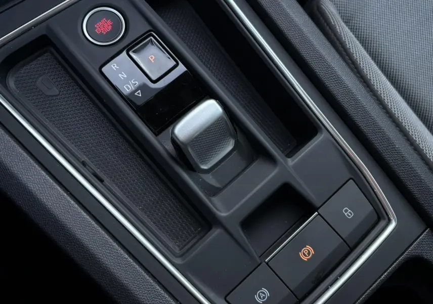 Gros plan sur la console centrale noire du SEAT LEON 1.5 eTSI 115 DSG Style 2025 avec levier de vitesse automatique et bouton start/stop.