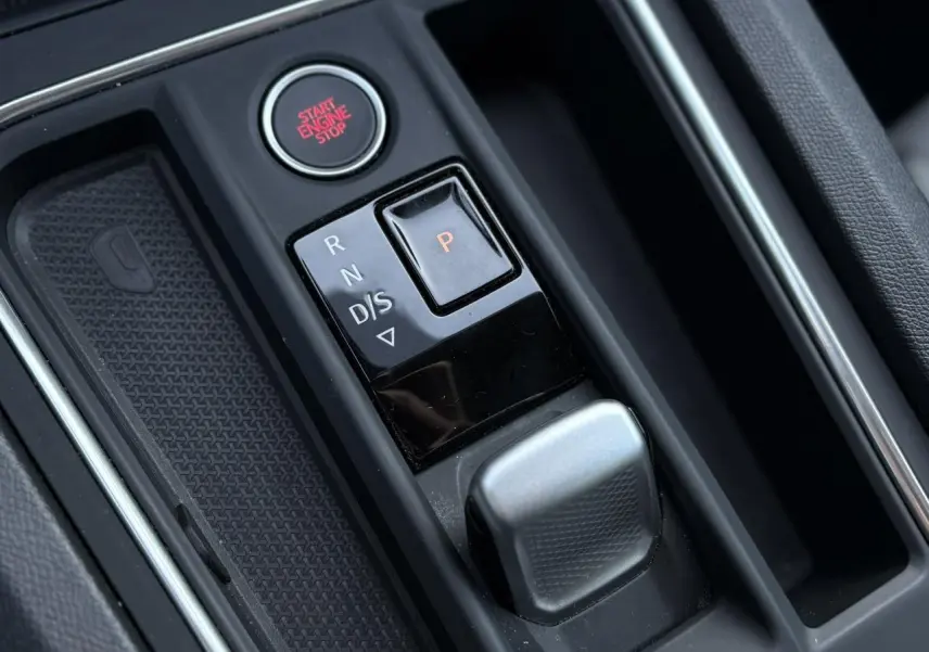 Gros plan sur la console centrale de la SEAT LEON 1.5 eTSI 115 DSG Style 2025, montrant la commande de boîte auto et le bouton start/stop.