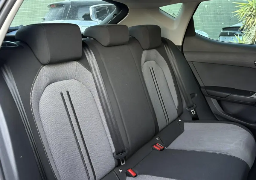 Vue latérale droite des sièges arrière gris et noirs du SEAT LEON 1.5 eTSI 115 DSG Style 2025, intérieur spacieux et moderne.
