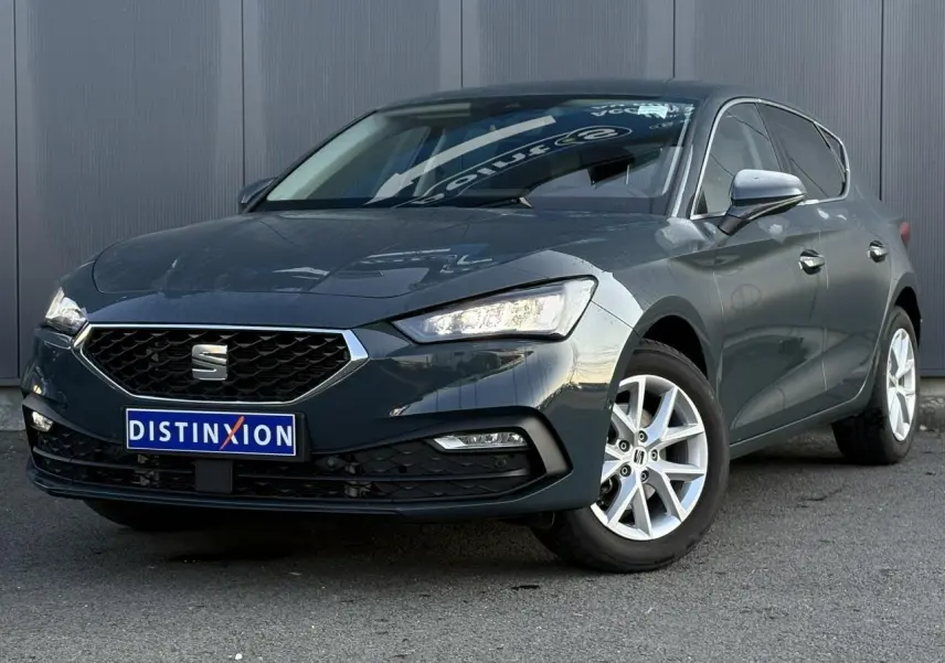 SEAT Leon 1.5 eTSI 115 DSG Style bleu Fjord vue 3/4 avant avec jantes alliage et projecteurs LED allumés.