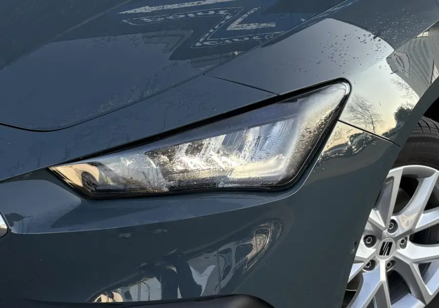 Gros plan sur le projecteur avant droit et la jante alliage 16 pouces d'une SEAT LEON Bleu Fjord 2025.