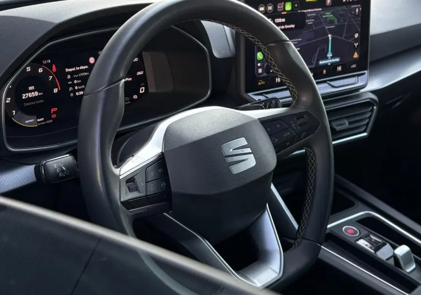 Vue rapprochée du volant cuir multifonction et du tableau de bord numérique du SEAT LEON Bleu Fjord 2025.