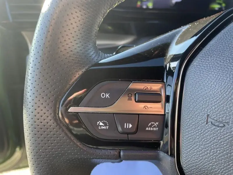 Gros plan sur les commandes au volant côté gauche du Peugeot 308 1.5 HDI 130 GT PACK EAT8, cuir perforé noir.