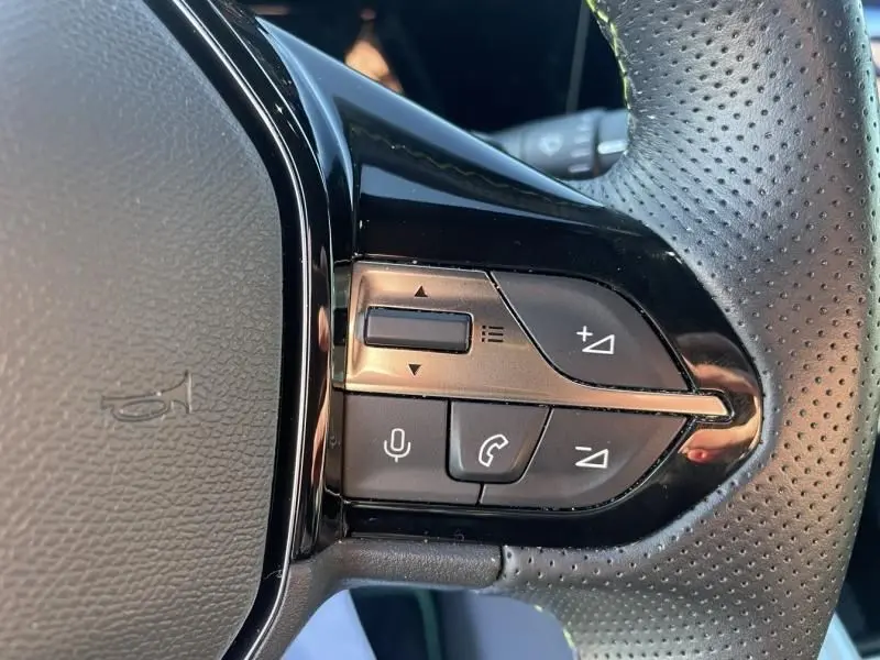 Gros plan sur les commandes au volant côté droit du Peugeot 308 1.5 HDI 130 GT PACK EAT8 2022 en vert olivine.
