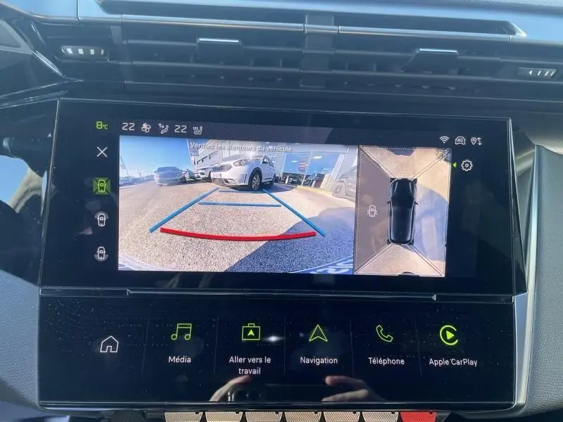 Écran de recul affichant une Peugeot 308 vert olivine vue de l’arrière avec guidage de trajectoire et vue 360° intérieure.