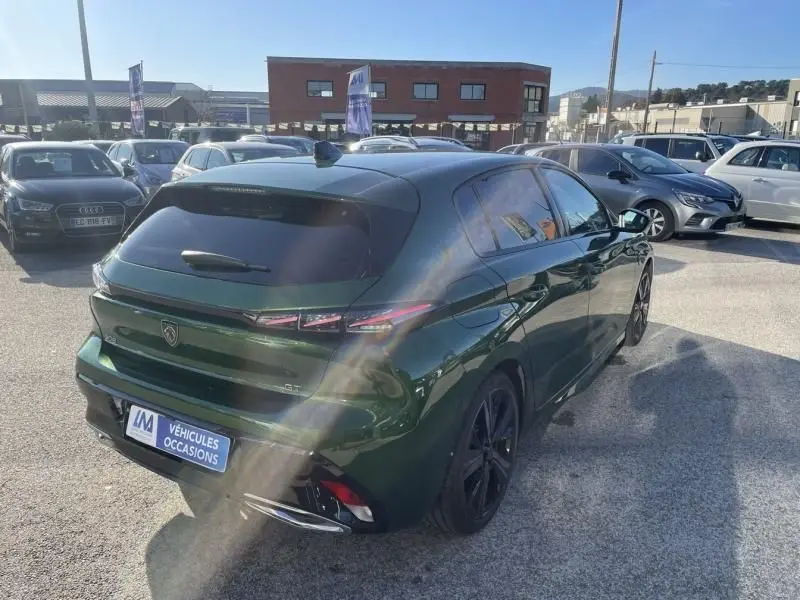 Peugeot 308 1.5 HDI 130 GT Pack 2022 en vert olivine, vue 3/4 arrière droit avec feux arrière LED distinctifs.