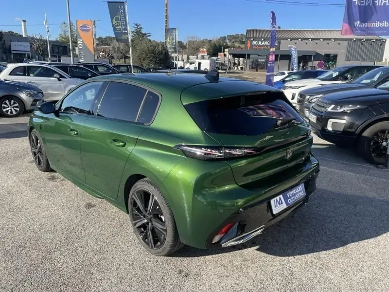 Peugeot 308 1.5 HDI 130 GT PACK 2022 en vert olivine, vue 3/4 arrière droit avec jantes noires et vitres teintées.
