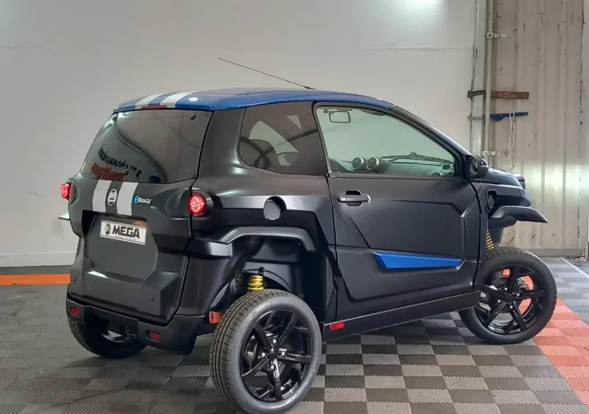 Vue 3/4 arrière droite de l'AIXAM MEGA E-SCOUTY EVO 2026 bleu mat avec bandes blanches et jantes noires.