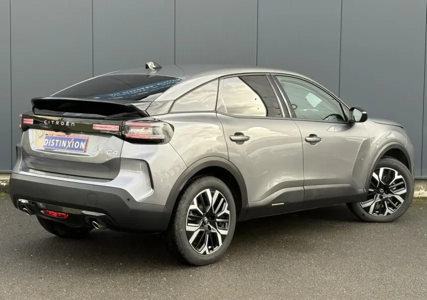 Vue 3/4 arrière droit d'une Citroën C4 Hybrid 145 gris Mercury avec jantes alliage et toit noir brillant.