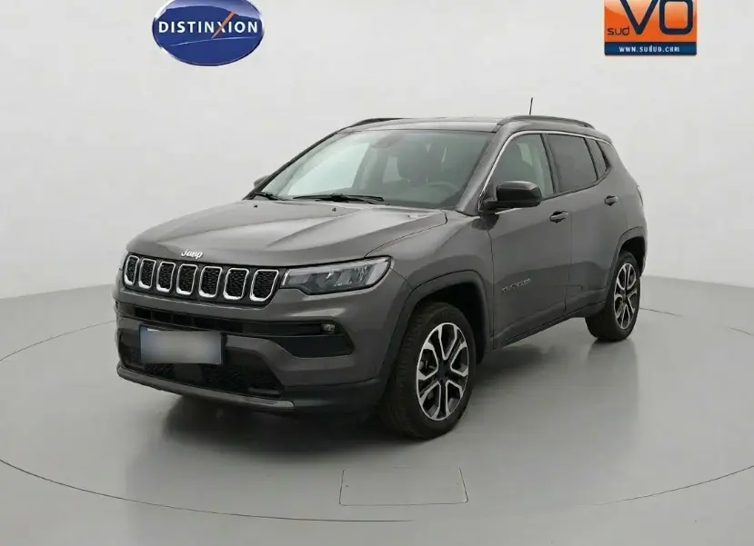 Vue 3/4 avant d'un Jeep Compass gris 2024 avec jantes alliage 18 pouces et calandre distinctive à sept fentes.