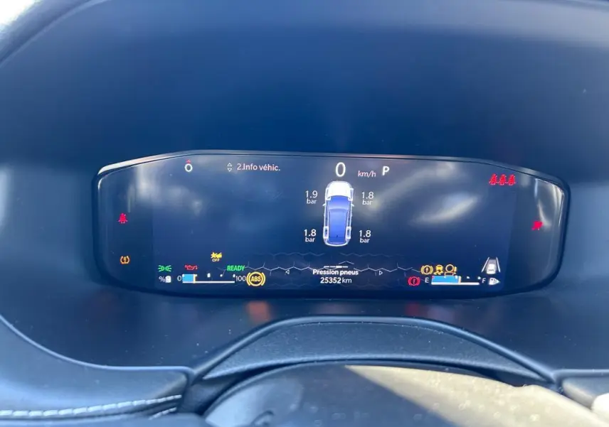 Vue rapprochée du tableau de bord numérique du Jeep Compass gris 2024 affichant la pression des pneus et les alertes.