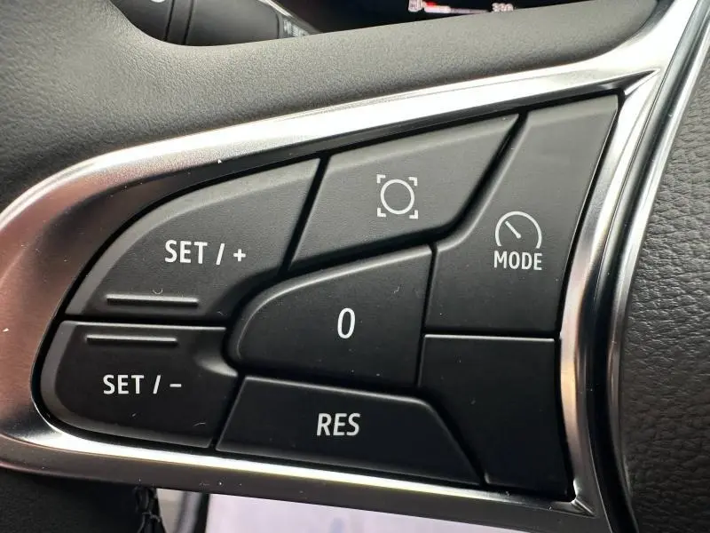 Gros plan sur les commandes noires du volant multifonction du Renault Captur 2025, entourées de chrome.