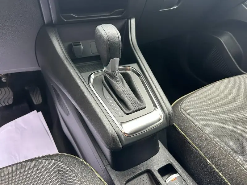 Gros plan sur la console centrale et levier de vitesse automatique noir du Renault Captur rouge, intérieur tissu gris.