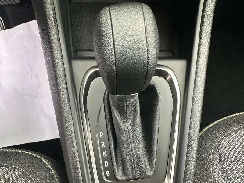 Gros plan sur le levier de vitesses automatique noir du Renault Captur rouge, vue de dessus de la console centrale.