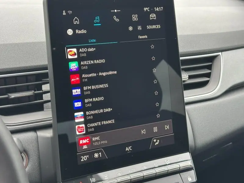 Écran tactile central du Renault Captur 2025 affichant la liste des radios DAB, avec tableau de bord gris en arrière-plan.