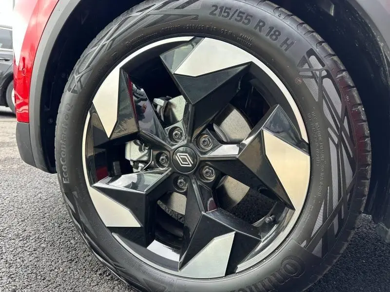 Gros plan sur la jante alu noire et argentée du Renault Captur rouge, mettant en valeur le logo Renault central.