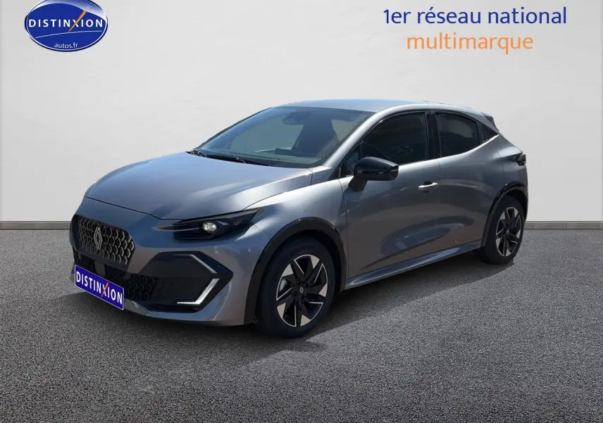Renault Clio VI gris schiste en 3/4 avant droit, avec jantes alliage et phares LED allumés.