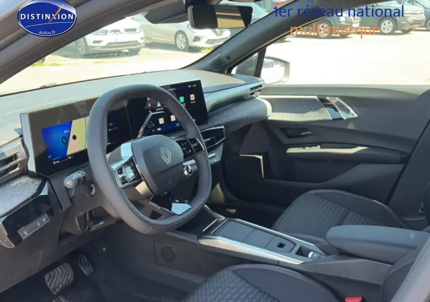 Vue intérieure côté conducteur de la Renault Clio VI gris schiste, avec tableau de bord numérique et volant multifonctions.