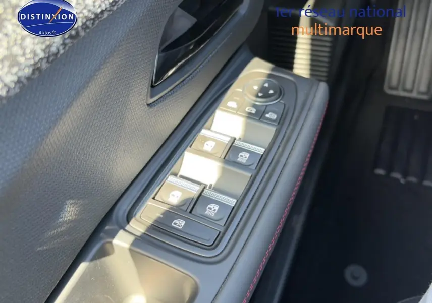 Gros plan sur la commande des vitres électriques côté gauche de la Renault Clio VI, avec surpiqûres rouges visibles.