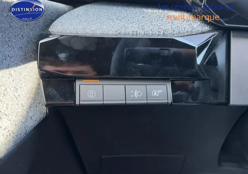 Gros plan sur les commandes de réglage des phares et verrouillage, intérieur noir de la Renault Clio VI gris schiste.