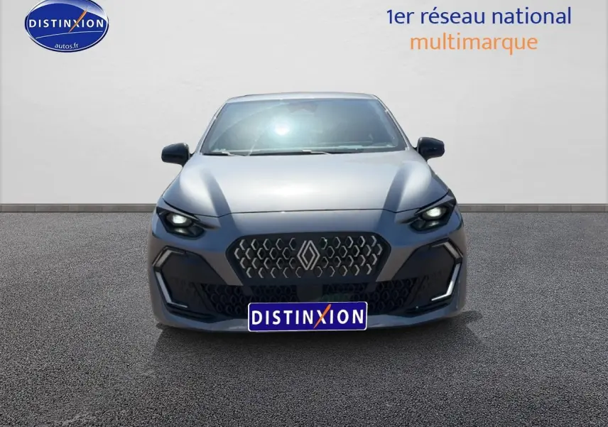 Vue frontale d'une Renault Clio VI gris schiste avec calandre hexagonale et phares LED allumés.