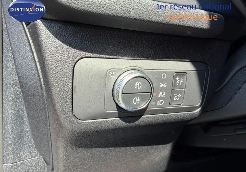 Gros plan sur le panneau de commande des phares du Ford Kuga 2024, finition ST-LINE, intérieur noir texturé.
