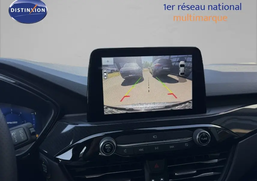 Vue intérieure du tableau de bord du Ford Kuga 2024 gris magnétique, avec écran central affichant la caméra de recul.