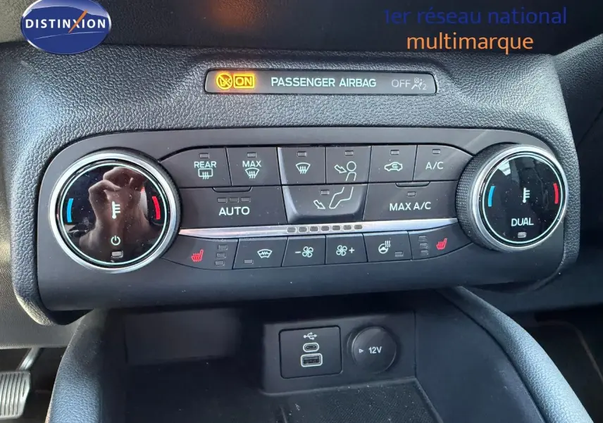 Gros plan sur la console centrale du Ford Kuga 2024 gris magnétique, montrant les commandes de climatisation et ports USB/12V.
