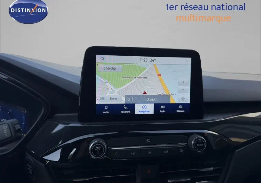 Vue intérieure du tableau de bord du Ford Kuga 2024 avec écran tactile de navigation affichant une carte.