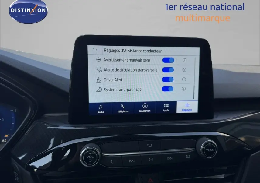 Vue intérieure du tableau de bord du Ford Kuga 2024, écran tactile affichant les réglages d’assistance conducteur.