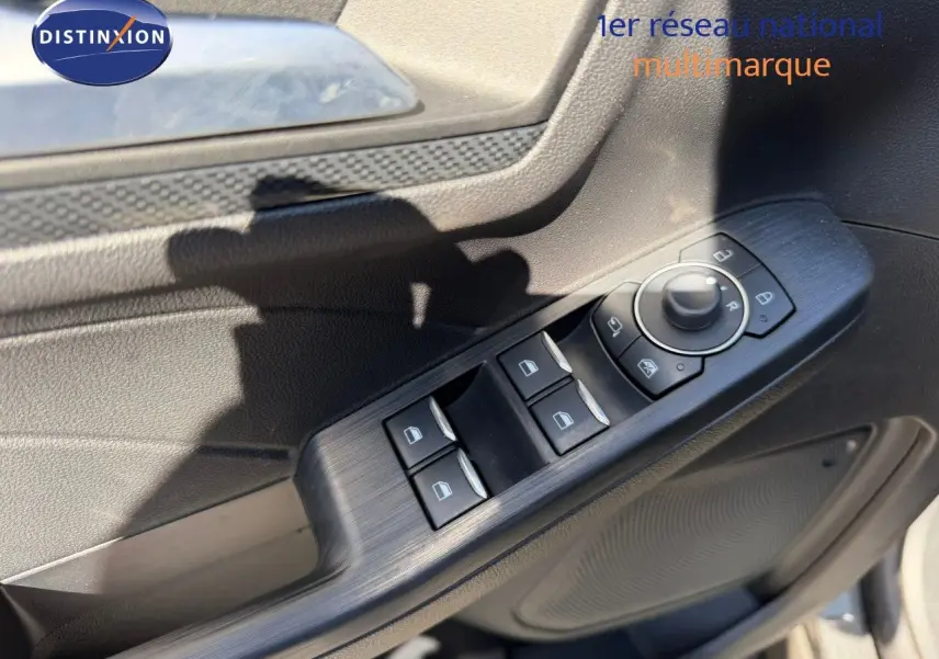 Détail des commandes de lève-vitres et rétroviseurs sur la portière côté gauche d’un Ford Kuga gris magnétique 2024.