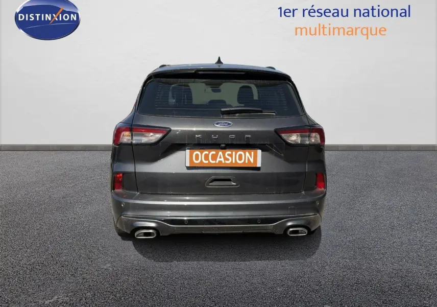 Vue arrière d'un Ford Kuga 2.0D EcoBlue gris magnétique métal avec double sortie d'échappement et badge ST-Line visible.