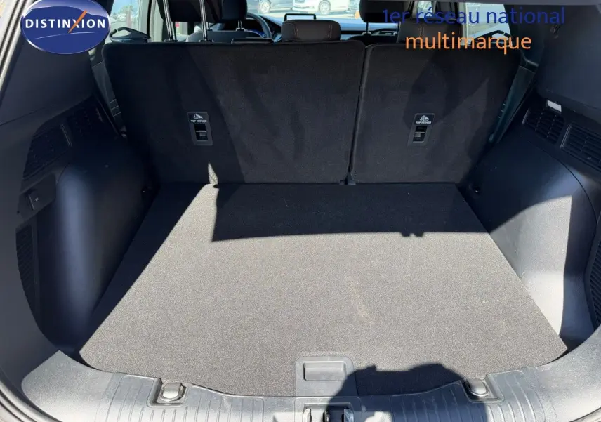 Coffre ouvert du Ford Kuga gris magnétique 2024, vue arrière montrant l’espace de chargement et les dossiers de sièges noirs.