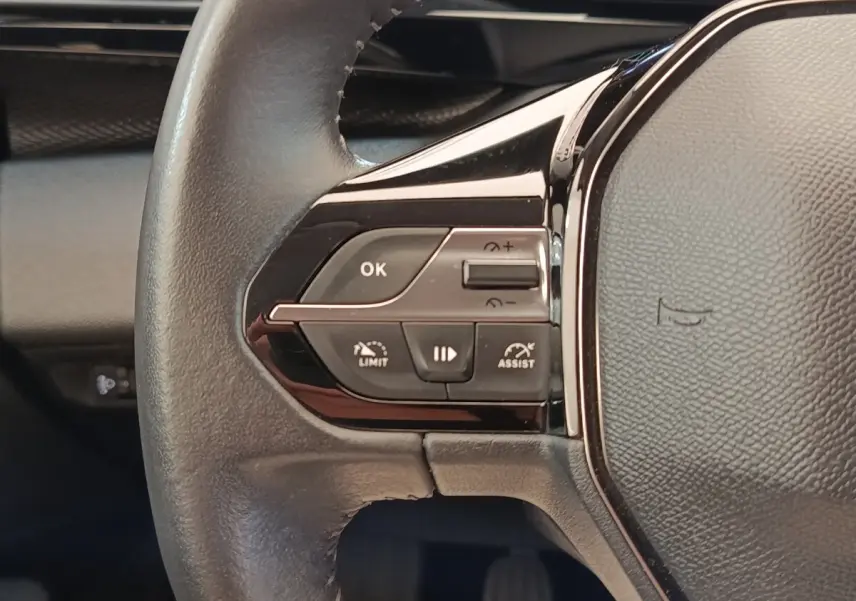 Gros plan sur le volant cuir noir de la Peugeot 308 2023 avec commandes multifonctions et régulateur de vitesse.