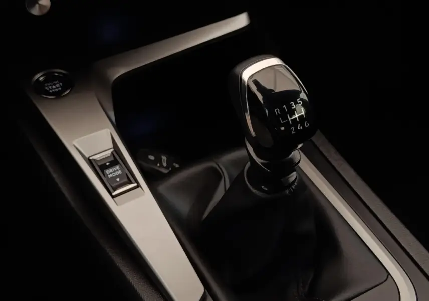 Gros plan sur le levier de vitesses manuel noir et la console centrale argentée de la Peugeot 308 PureTech 130 S&S ACTIVE PACK.
