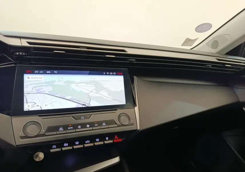 Vue intérieure du tableau de bord de la Peugeot 308 2023 avec écran tactile central affichant la navigation.