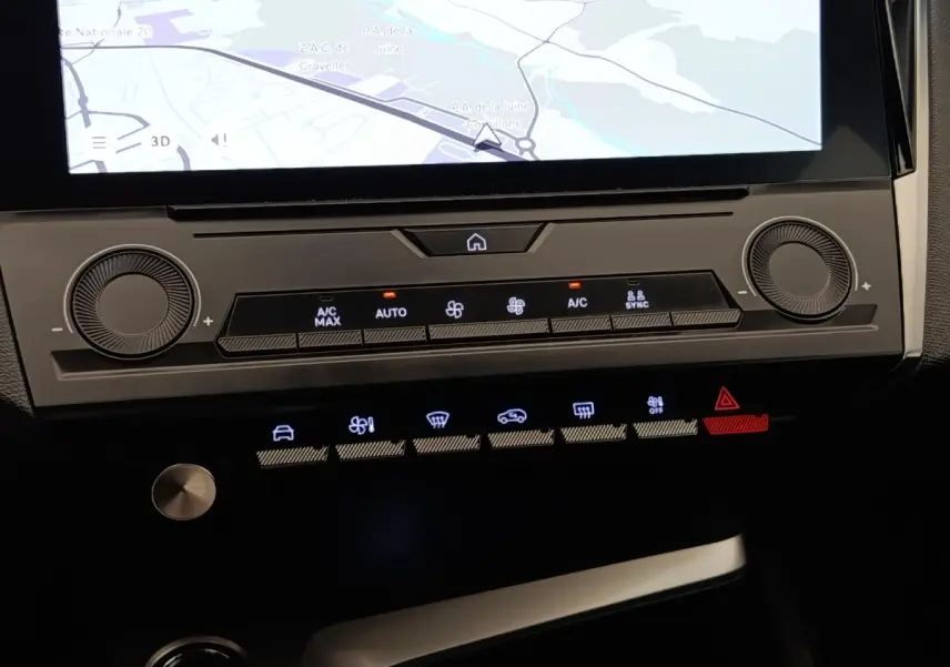 Vue rapprochée du tableau de bord central de la Peugeot 308 2023, avec écran tactile et commandes climatisation éclairées.