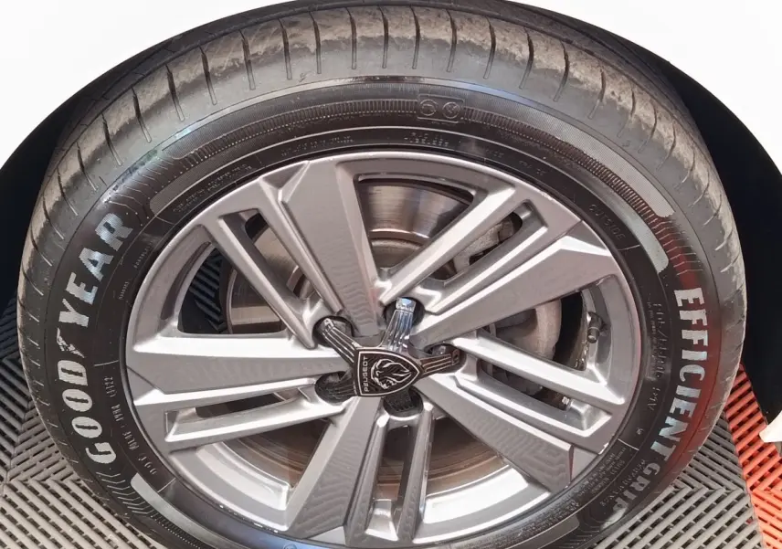Gros plan sur la roue avant droite d'une Peugeot 308 blanche avec jante alliage et pneu Goodyear Efficient Grip.