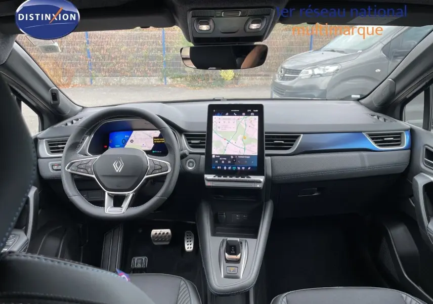 Vue intérieure avant du Renault Symbioz gris cassiopée métal, avec tableau de bord numérique et écran tactile central vertical.