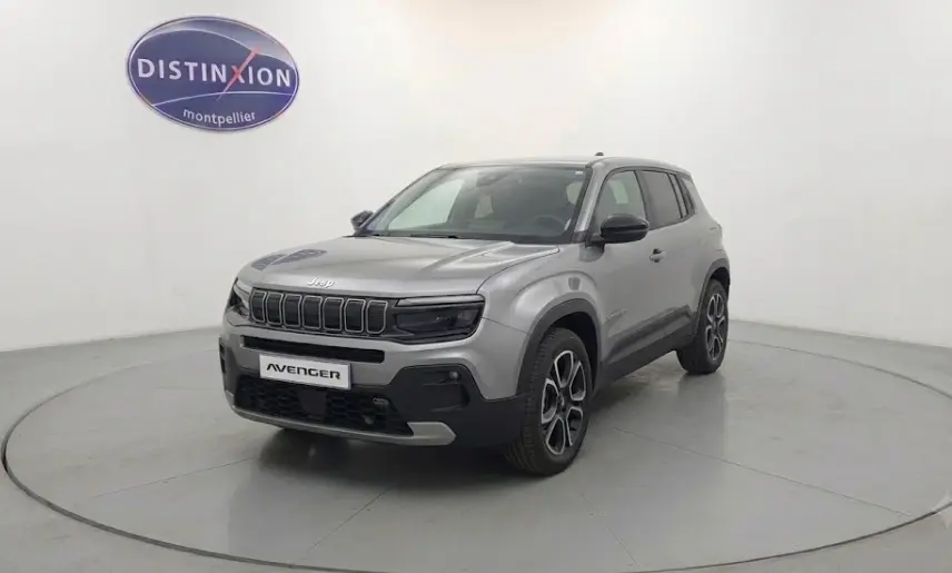 Jeep Avenger gris foncé en 3/4 avant droit, avec calandre noire distinctive et jantes au design moderne.