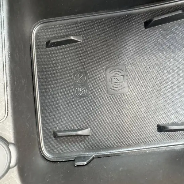Gros plan sur le support de recharge sans fil noir dans l'habitacle du Jeep Avenger gris foncé 2025.