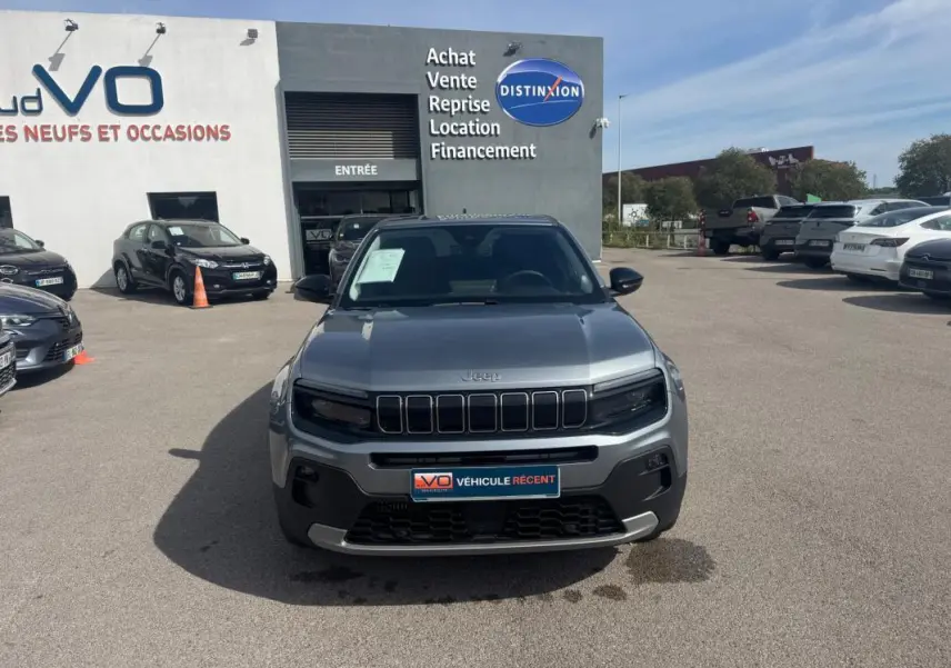 Vue frontale du Jeep Avenger gris foncé 2025, avec sa calandre distinctive à sept fentes et ses phares noirs intégrés.